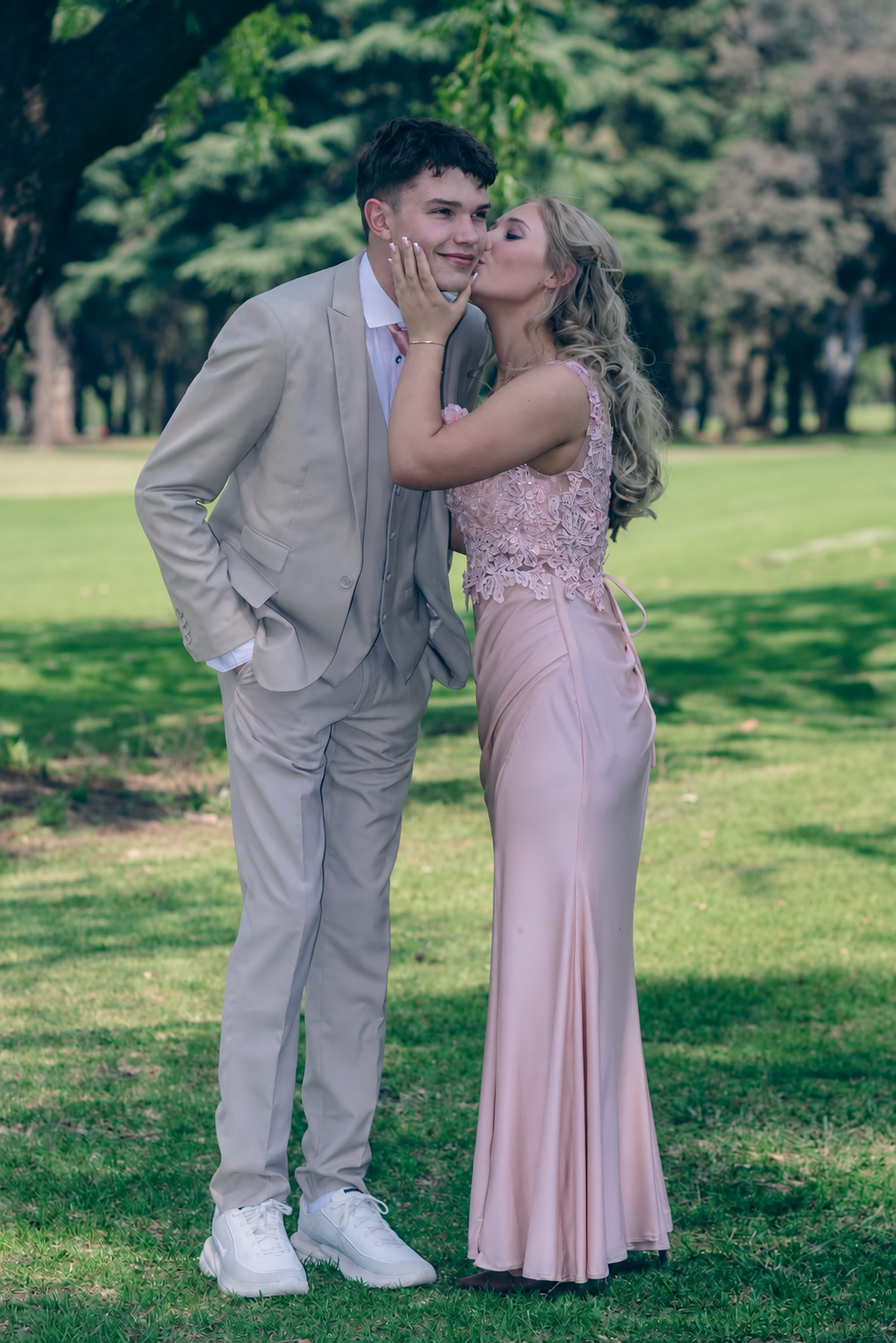 Matric farewell couple sharing a kiss in a pink dress and grey suit