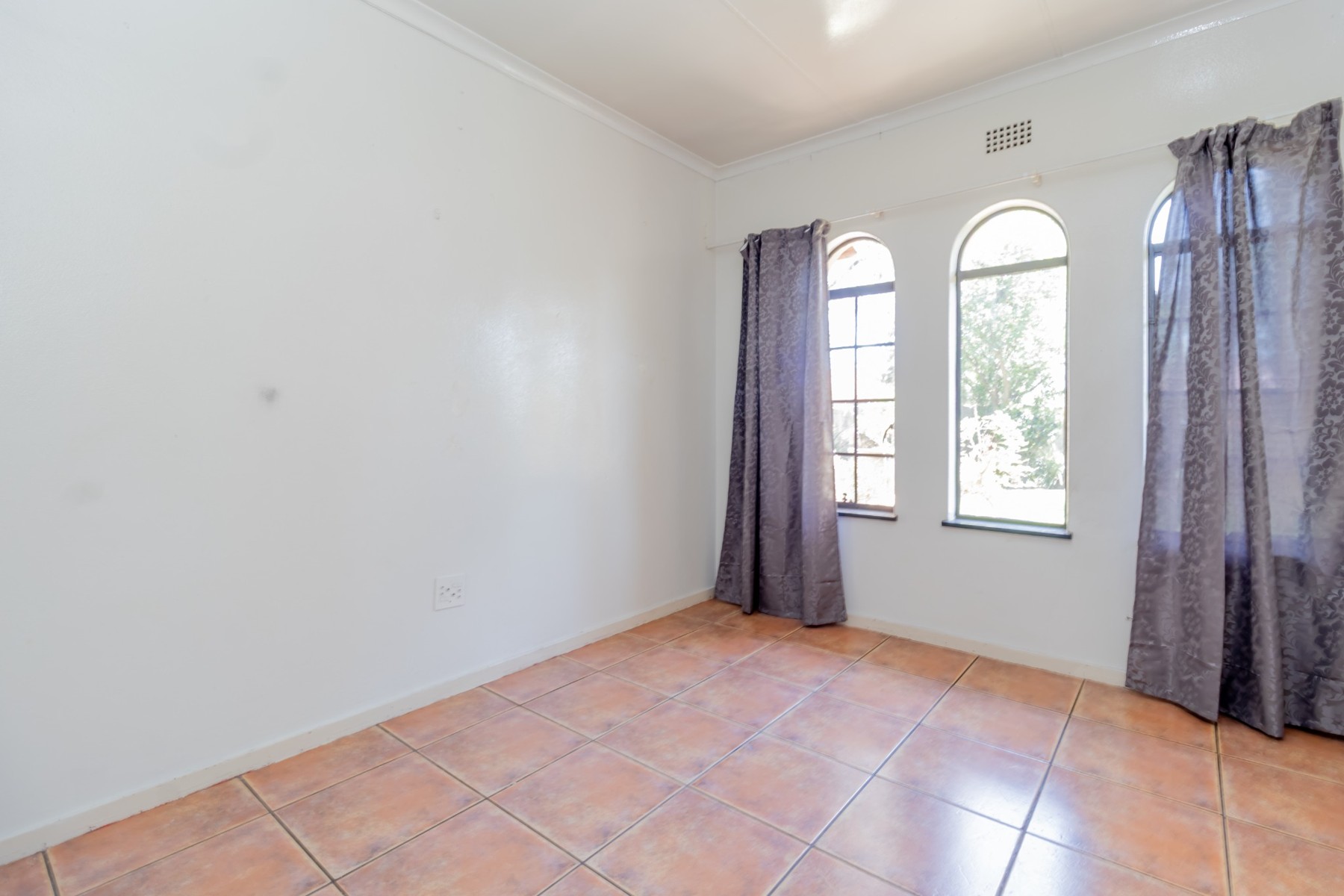 Bedroom with arched windows and tiled floors